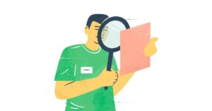 Henkilö tarkastelee suurennuslasilla vaaleanpunaista paperia vihreässä paidassa.